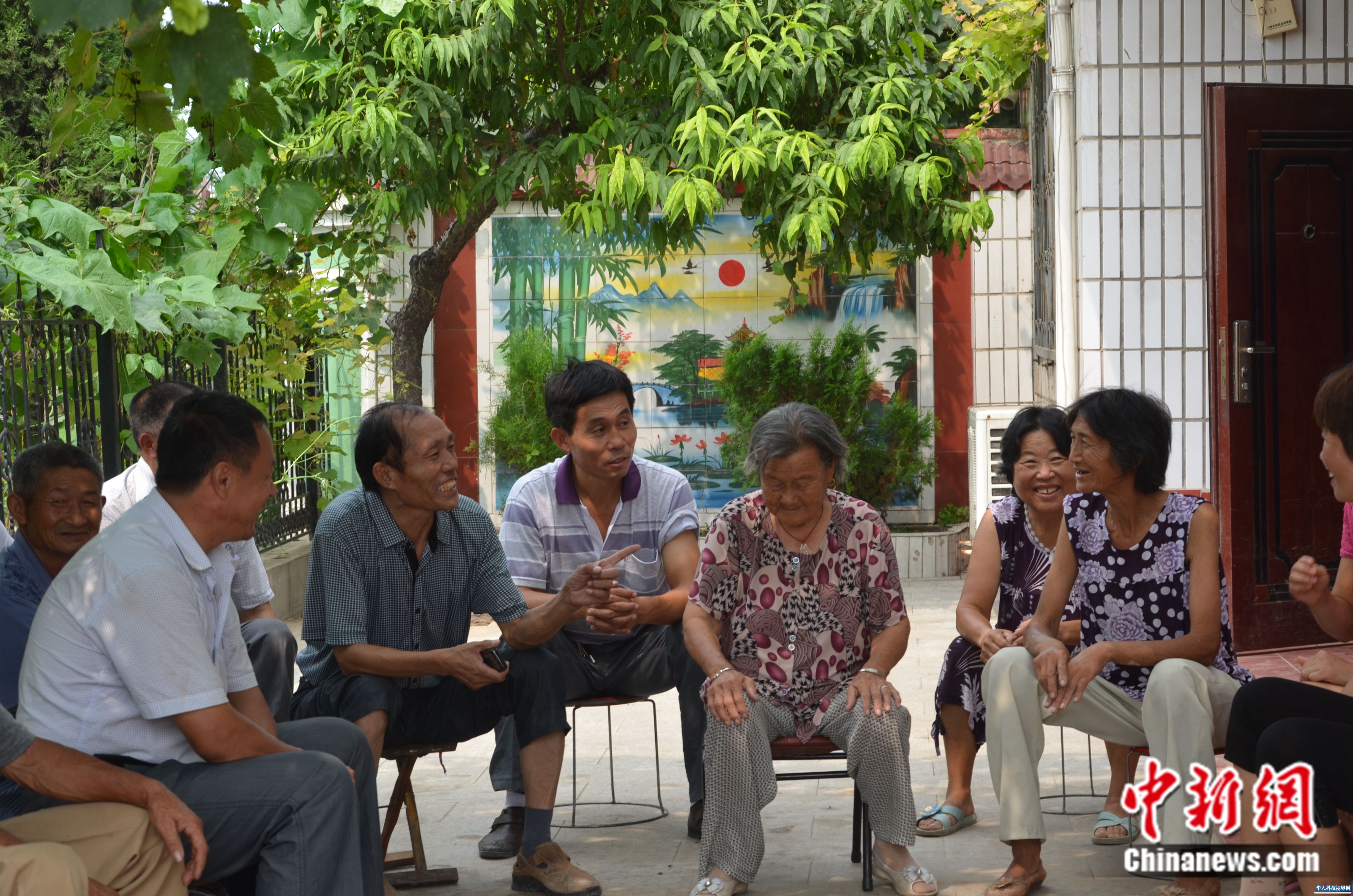 2012年8月11日，李连成同村民一起商议村内发展规划。西辛庄供图
